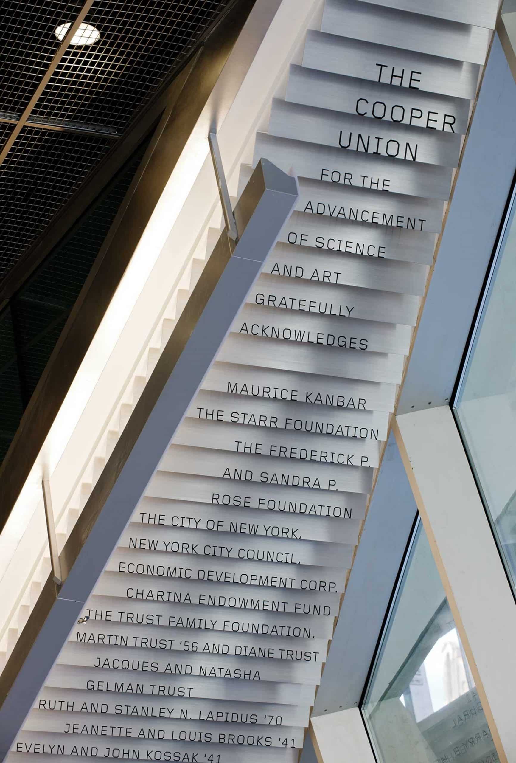 Donor signage cascades down the underside of a lobby staircase.